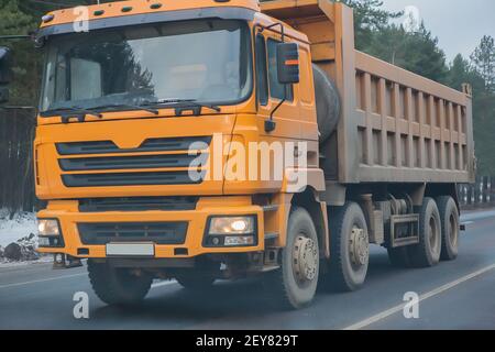 big dump truck goes on highway in winter Stock Photo