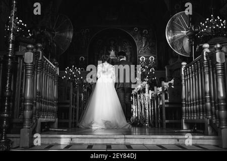 back view of bride and groom walking to the altar Stock Photo