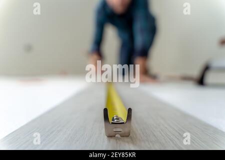 Close up of a meter to measure a wooden floor. Man measuring out of focus Stock Photo