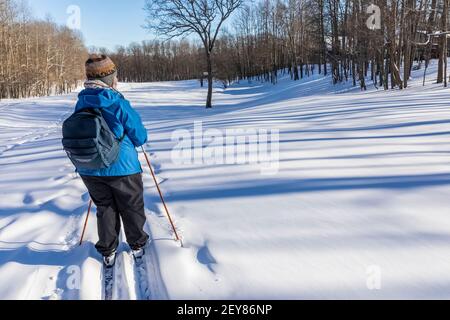 Karen Rentz cross-country skiing on a beautiful day in central Michigan, USA Stock Photo