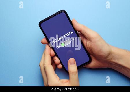 The person on the smartphone display turns on the 5G network. Stock Photo