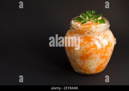 Sour cabbage in the glass jar on the black background with copy space Stock Photo