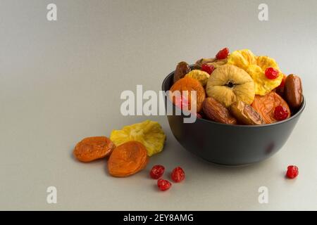 Different dried fruits in the black bow on the gray background Stock Photo
