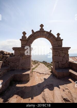 Traditional old stone rock arch welcome entrance gate on Taquile Island walkway path Lake Titicaca Puno Peru South America Stock Photo