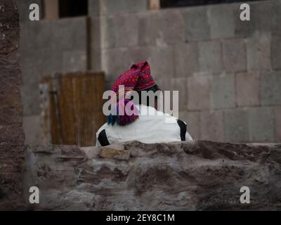 Old indigenous man wearing typical traditional white costume with red colorful knit cap bobble hat on Taquile Island Titicaca Lake Puno Peru South Ame Stock Photo