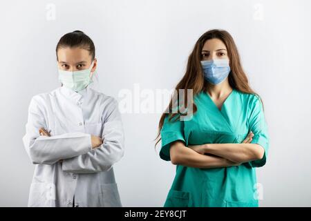 Two female nurses in medical masks looking at camera Stock Photo