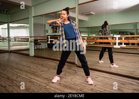 Pretty young woman vlogger showing dance move.A young woman is engaged in contemporary dance alone in the choreography hall. Self-training.