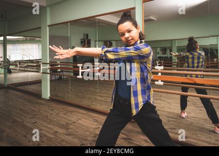 Pretty young woman vlogger showing dance move.A young woman is engaged in contemporary dance alone in the choreography hall. Self-training.