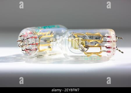Two old electronic vacuum radio tubes isolated on white background. Transparent lamps produced by the Soviet Union. Vintage glass tube transistors clo Stock Photo