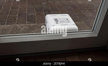 a white styrofoam package outside the front door on the doorstep, Denmark, Mars 4, 2021 Stock Photo