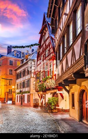 Strasbourg, France. Traditional Alsace half-timbered houses in Petite France during twilight decorated  at Christmas time. Stock Photo