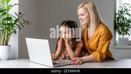 Helpful mother explaining to daughter about using a laptop Stock Photo