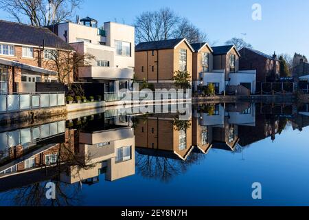 Modern houses reflected in the Ashton Canal, Audenshaw, Tameside, Manchester, England, UK.  The three on the right are called 'The Boatyard'. Stock Photo