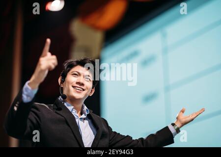 Asian Businessman Stands on Stage for Business Presentation Stock Photo