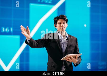 Asian Businessman Stands on Stage for Business Presentation Stock Photo