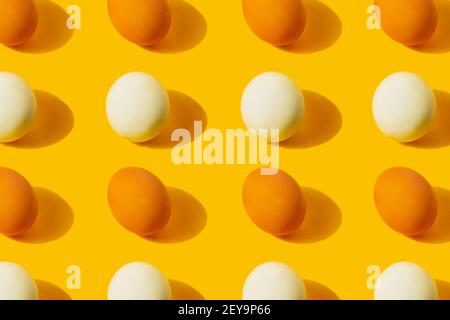 Farm chicken fresh and boiled eggs pattern on yellow background with copy space. Healthy food or Happy Easter creative minimal concept. Flat lay Stock Photo
