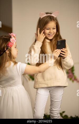 two little girls with phones. friendship concept happy little girls taking selfie with smartphone Stock Photo