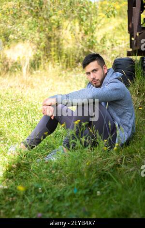 A handsome sporty man sitting and relaxing in nature Stock Photo