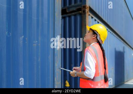 Asian worker woman is checking the container after the repair complete to prepare the delivery to the customer. Stock Photo