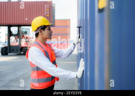 Asian worker man using Chipping Hammer tool for checking the container after the repair complete to prepare the delivery to the customer. Stock Photo