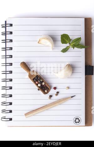 Brown notebook for writing recipe or menu on wooden table. Spices for ...