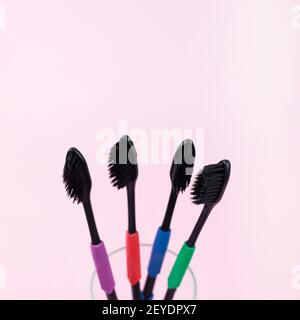 Eco toothbrushes made of bio degradable plastic and bamboo active charcoal on light pink background, copy space Stock Photo