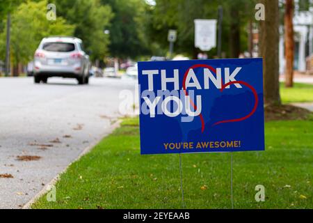 a yard sign by street saying 'Thank you, you are awesome' in white and orange text on blue background. A red heart symbol is embedded. Customizable ve Stock Photo