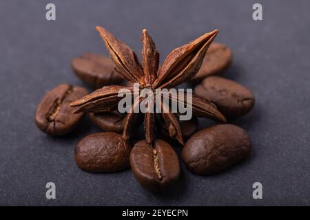 Anise star on grains coffee. Сinnamon with roasted coffee beans on the cloth grey background. View from front. Stock Photo