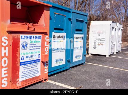 Rockville, Maryland, USA 03-02-2021: Large metal clothing and shoes donation bins lined side by side on a parking lot. They help reduce waste and bene Stock Photo