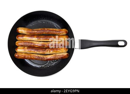 Close-up of five fried traditional german pork sausages on a frying pan isolated on white background. Stock Photo