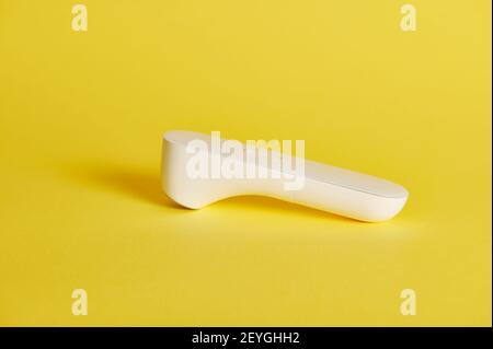 Closeup image of an infrared electronic non-contact thermometer for measuring body temperature on the forehead. Stock Photo