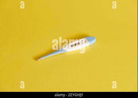 Flat lay composition of a digital Thermometer on yellow background. Copy space. Studio shot with soft shadow Stock Photo