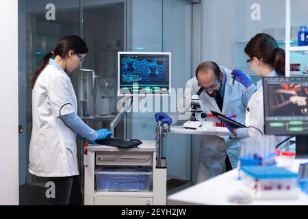 Group of scientists doing research and experiments at medical lab against disease with special equipment. Doctors specialists doing scientific experiment and searching medical treatment Stock Photo