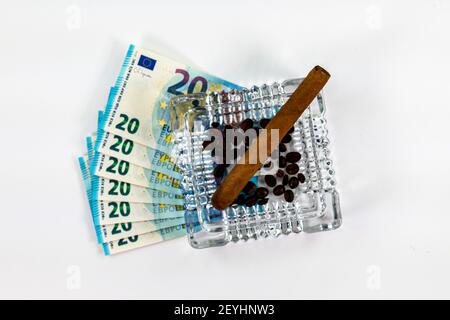 of 20 euro banknotes with ashtray and cigar on white background Stock Photo