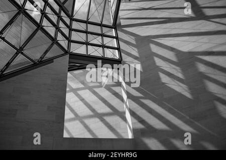 Abstract black and white image of square windows and shades dropped on concrete wall Stock Photo