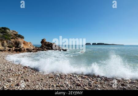 waves splashing onto a pebble beach in winter Stock Photo