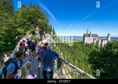 Tourists at the Marienbrücke (Mary's Bridge), a pedestrian bridge allowing a stunning view of Neuschwanstein Castle, near Füssen, Bavaria, Germany Stock Photo
