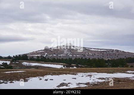 white domes of the radar complex on a hilltop on a cold plateau Stock Photo