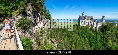 View of famous and amazing Neuschwanstein Castle, Bavaria, Germany, seen from the Marienbrücke (Mary's Bridge), a pedestrian bridge built over a cliff Stock Photo
