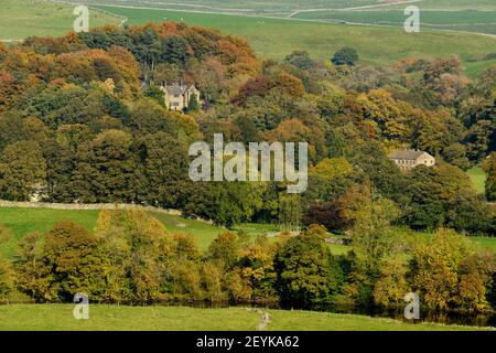 Scenic Wharfedale autumn (River Wharfe, houses nestling in hillside woodland, colourful foliage on trees, upland fields - Yorkshire Dales, England, UK Stock Photo