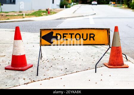 Yellow road detour sign between two traffic cones Stock Photo