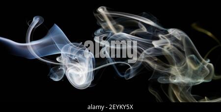 Blue and yellow abstract smoke shapes on black isolated background Stock Photo