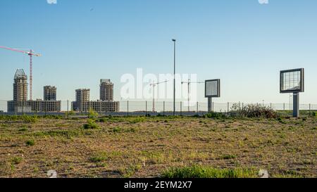 Two blank billboards, two building blocks under construction, and two cranes on the construction site, St. Petersburg, Russia Stock Photo