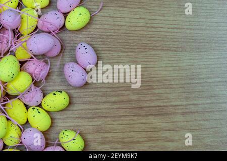 Colorful Yellow and Pink easter egg with freckle patterns on wooden table with copy space Stock Photo