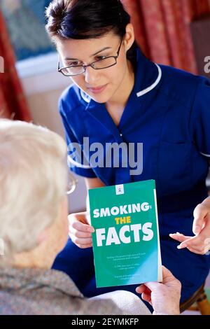 District nurse visiting elderly woman at her home Stock Photo