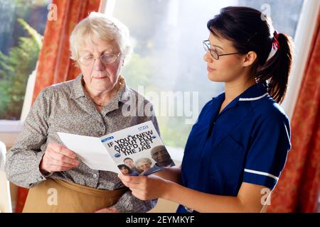 District nurse visiting elderly woman at her home Stock Photo