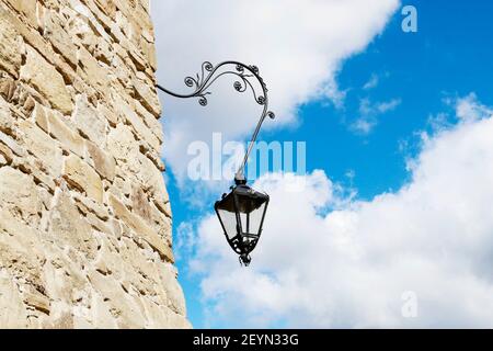 Heavy steel black lantern on old castle wall. Graphic resources Stock Photo