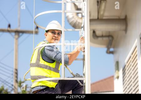 Young man worker or engineer climb ladder. Stock Photo