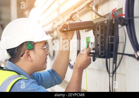 Engineer repair connector the fibers on splitter tray close-up outside Stock Photo