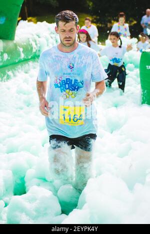 BOLTON, UNITED KINGDOM - Jul 14, 2018: A selection of event Photos from the BubbleRush charity foam party race for Bolton Hospice with runners racing Stock Photo